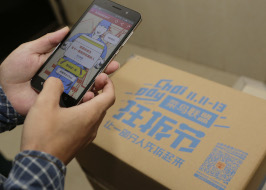 Customer uses his smartphone to scan QR code on the parcel from online shopping