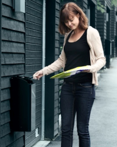 woman collecting letters from her mailbox